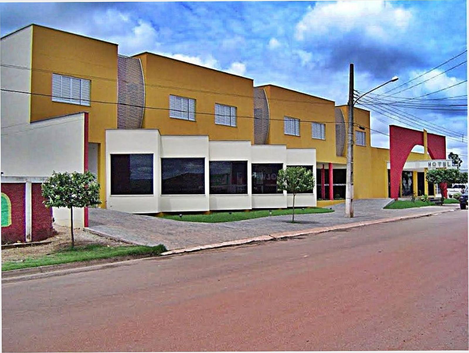 Fachada do Hotel Flor da Mata em tons de amarelo e branco, vista da rua no centro de Guarantã do Norte