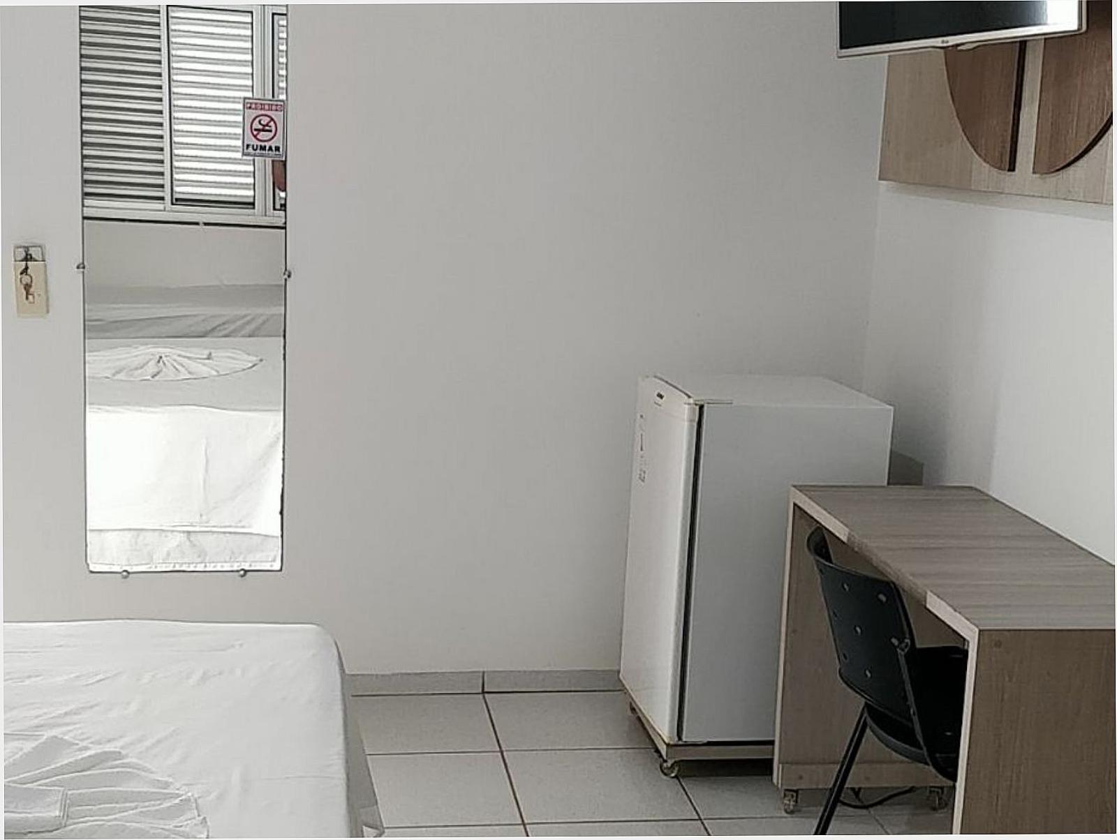 Quarto com escrivaninha, espelho e cama de solteiro